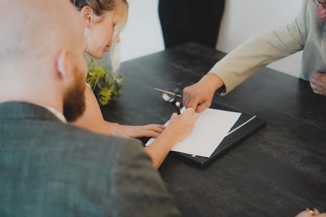 Two parents signing a Voluntary Declaration of Parentage together at a desk